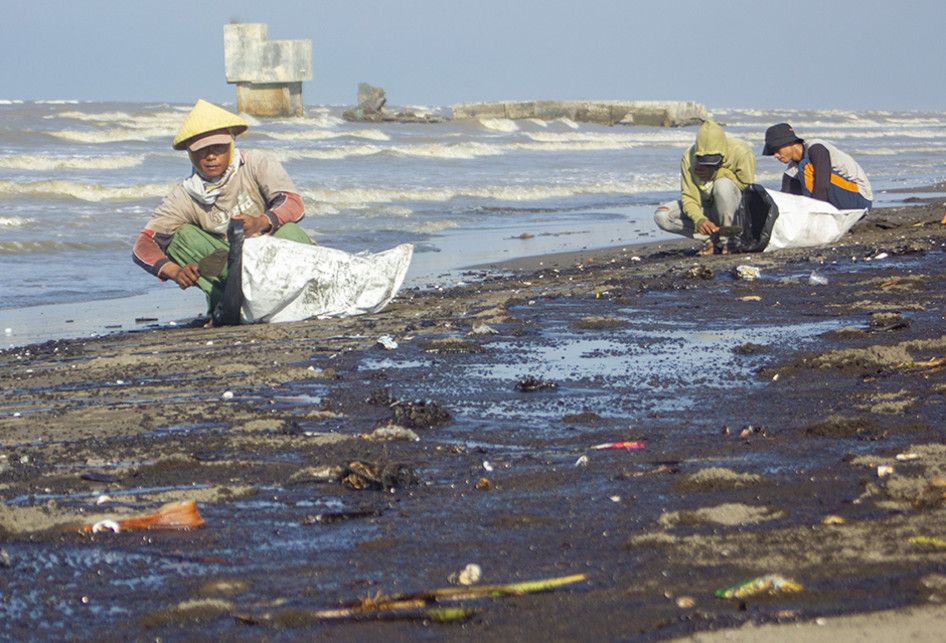 Warga mengumpulkan tumpahan minyak (Oil Spill) yang tercecer di Pesisir Pantai Cemarajaya, Karawang, Jawa Barat, Senin (22/7/2019). Tumpahan minyak tersebut tercecer di sepanjang pantai Sedari hingga pantai Cemarajaya akibat kebocoran pipa proyek eksplorasi minyak milik Pertamina.