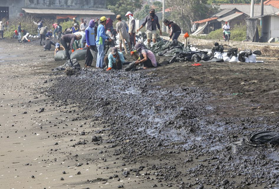 Warga mengumpulkan limbah tumpahan minyak "Oil Spill" yang tercecer milik Pertamina di Pesisir Pantai Cemarajaya, Karawang, Jawa Barat, Rabu (24/7/2019). Pasir yang tercemar minyak tersebut dikumpulkan dan akan dipindahkan ke pabrik penyimpanan limbah B3 (Bahan Berbahaya dan Beracun) untuk dimusnahk