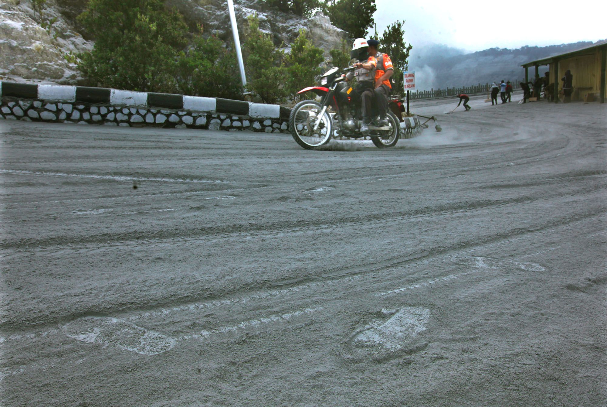 Petugas Kepolisian dari Polda Jabar berjaga dengan menggunakan motor di jalan menuju kawah Gunung Tangkuban Parahu, Desa Cikole, Kecamatan Lembang, Kabupaten Bandung Barat, Sabtu (27/7/2019). Menyusul erupsi pada Jumat (26/7), Taman Wisata Alam Tangkuban Parahu ditutup bagi wisatawan selama tiga har