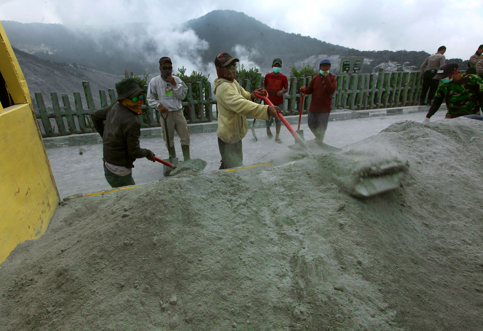 Sejumlah petugas diturunkan untuk membersihkan abu vulkanik yang bertebaran mencapai ketebalan 10 cm di jalan menuju kawah Gunung Tangkuban Parahu, Desa Cikole, Kecamatan Lembang, Kabupaten Bandung Barat, Sabtu (27/7/2019). Menyusul erupsi pada Jumat (26/7), Taman Wisata Alam Tangkuban Parahu ditutu