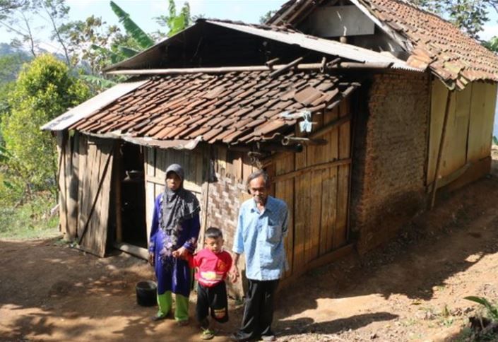 Sati (60), Jodi (7), dan Rakun (70) berdiri di sekitar rumahnya, di dusun pahing RT 1 RW 3, Desa Margabakti Kecamatan Kadugede Kabupaten Kuningan Jawa Barat, Senin (29/7/2019).