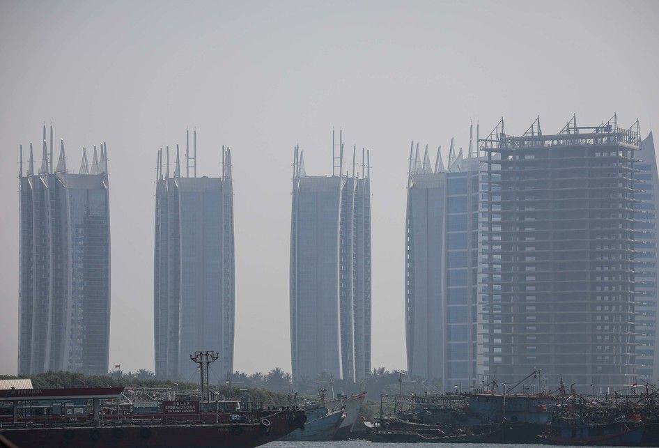 Pemandangan laut dengan latar belakang gedung bertingkat yang diselimuti asap polusi di Jakarta Utara, Rabu (31/7/2019). Berdasarkan data situs penyedia peta polusi daring harian kota-kota besar di dunia AirVisual, menempatkan Jakarta pada urutan pertama kota terpolusi sedunia pada Senin (29/7) pagi