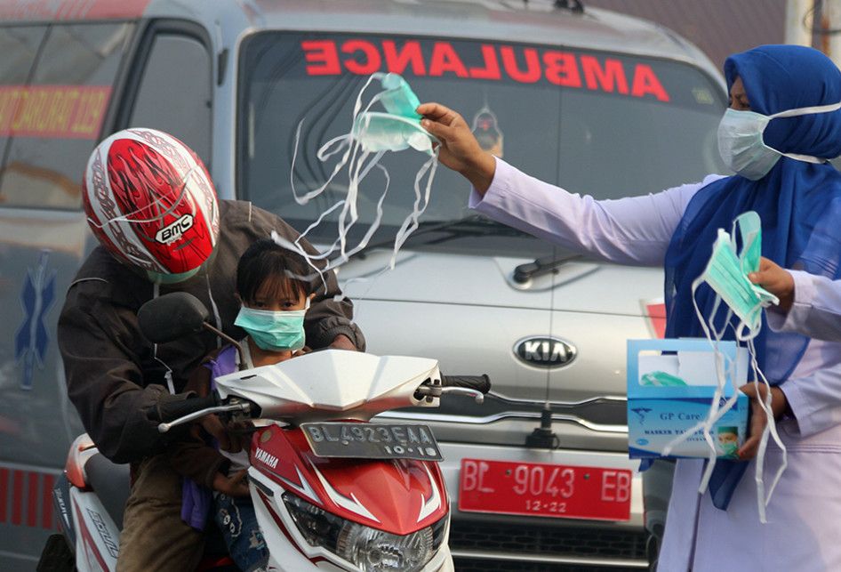 Petugas kesehatan dari Puskesmas Cot Simeureung, Kecamatan Samatiga dan Layung, Kecamatan Bubon, Kabupaten Aceh Barat, membagikan masker kepada pengguna jalan karena kabut asap kebakaran hutan dan lahan gambut yang sangat pekat, Kamis (1/8/2019). Selain kepada pengguna jalan, masker juga dibagikan kepada siswa empat sekolah yang terdampak kabut asap di Kecamatan Samatiga, yang berada di Desa Suak Timah dan Desa Blang Bale.