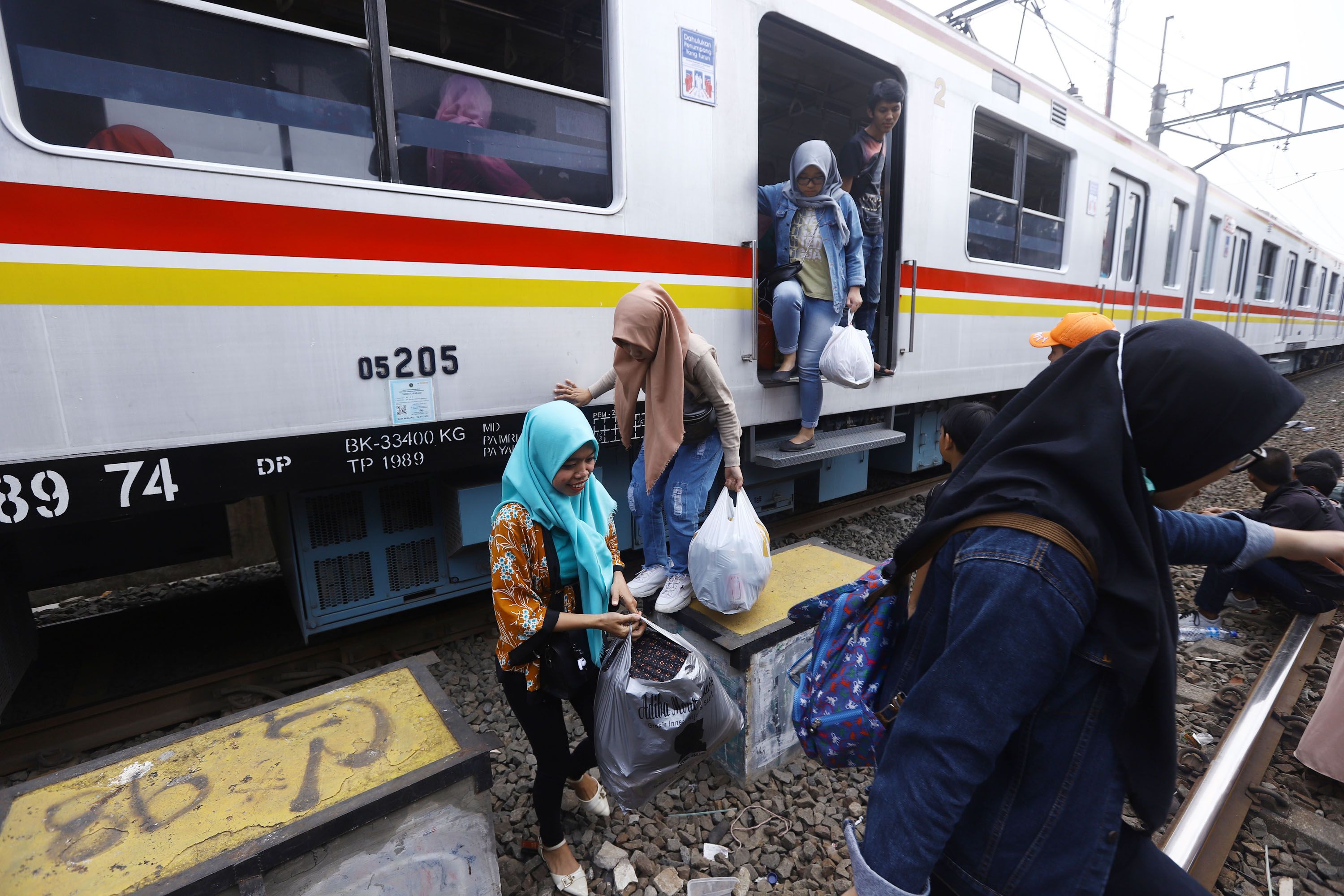 Penumpang terpaksa turun dari kereta rel listrik (KRL) yang berhenti di perlintasan Bukit Duri Jakarta Selatan, akibat padamnya listrik, Minggu (4/8/2019). Aliran listrik di Banten, Jabodetabek hingga Bandung terputus akibat adanya gangguan pada sejumlah pembangkit di Jawa. TRIBUNNEWS/HERUDIN 