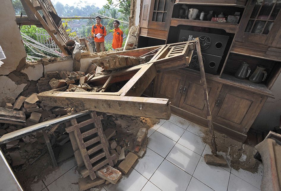 Relawan memeriksa rumah warga yang rusak akibat diguncang gempa di Kampung Karoya, Mandalawangi, Pandeglang, Banten, Sabtu (3/8/2019). Menurut data BPBD Banten satu orang meninggal dan sebanyak 112 rumah rusak berat dan ringan dengan rincian di Lebak sebanyak 12 rumah, di Pandeglang 91 rumah, dan di