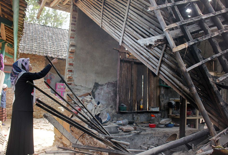 Warga menunjukkan bagian rumah yang rusak akibat gempa di Kampung Bojong, Pandeglang, Banten, Sabtu (3/8/2019). Gempa berkekuatan 6,9 M yang terjadi Jumat (2/8) malam mengakibatkan seorang meninggal dan 112 rumah rusak di Banten.