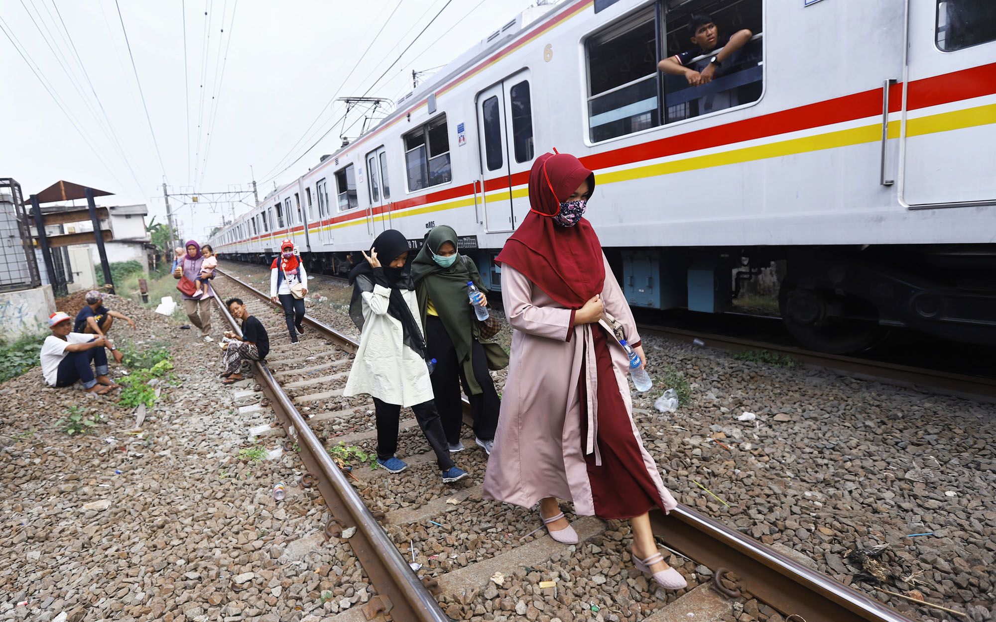 Penumpang terpaksa turun dari kereta rel listrik (KRL) yang berhenti di perlintasan Bukit Duri Jakarta Selatan, akibat padamnya listrik, Minggu (4/8/2019). Aliran listrik di Banten, Jabodetabek hingga Bandung terputus akibat adanya gangguan pada sejumlah pembangkit di Jawa. TRIBUNNEWS/HERUDIN 