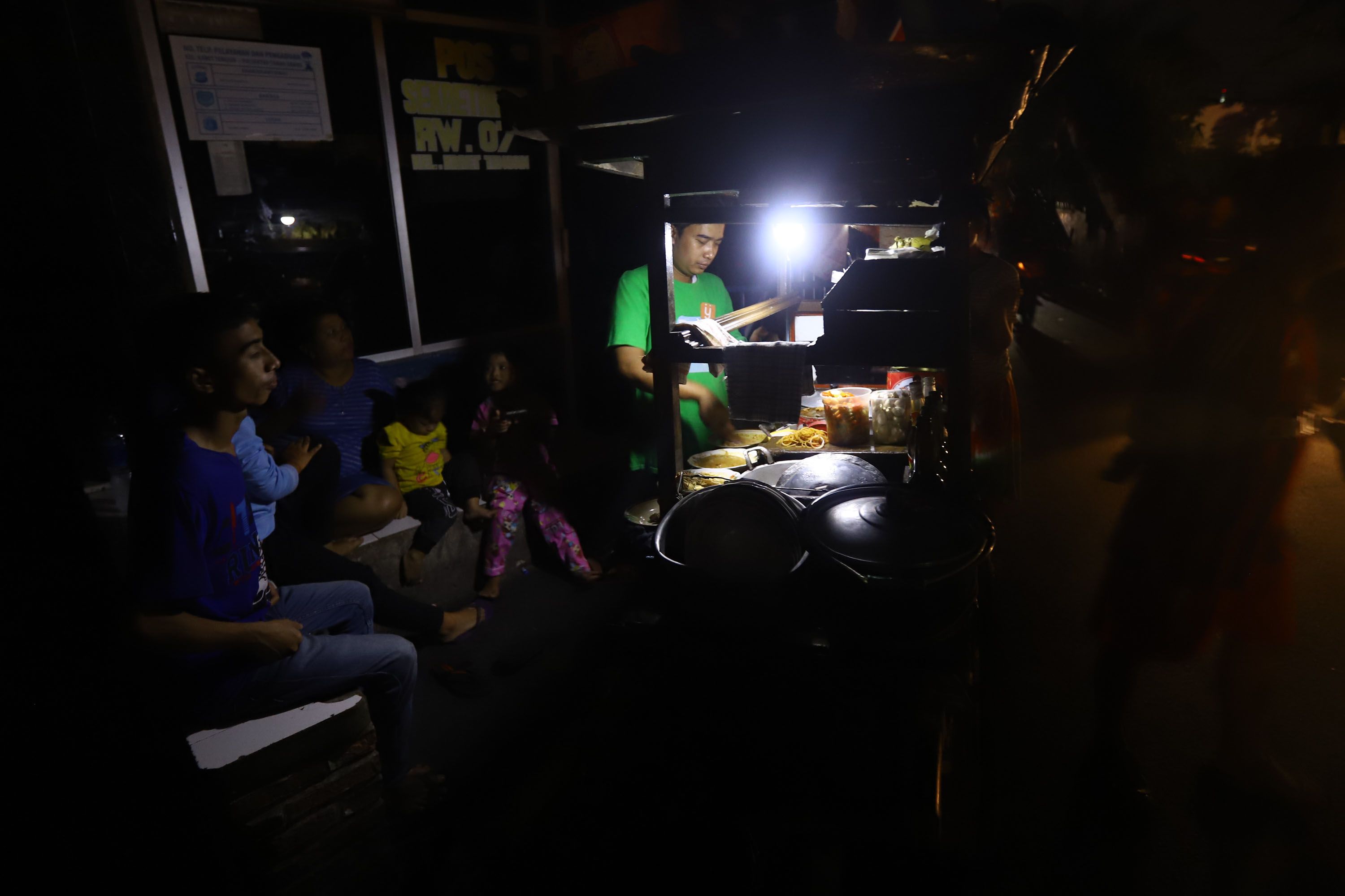 Warga beraktifitas menggunakan penerangan lilin dan lampu darurat, di wilayah Karet Tengsin Jakarta, Minggu malam (4/8/2019). Aliran listrik di Banten, Jabodetabek hingga Bandung terputus akibat adanya gangguan pada sejumlah pembangkit di Jawa. TRIBUNNEWS/HERUDIN 