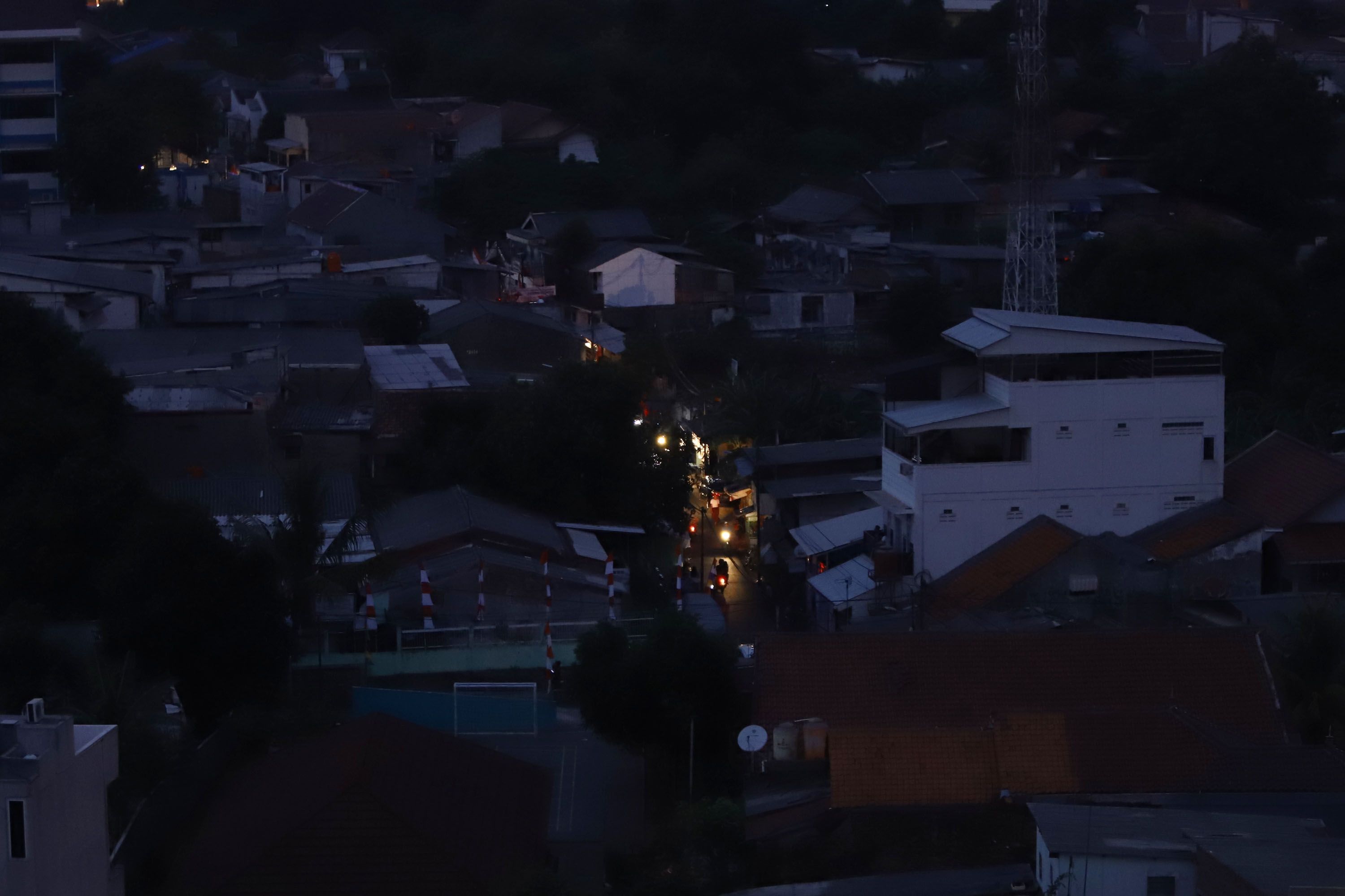 Permukiman warga Jakarta difoto dari Rusun Karet Tengsin terlihat gelap gulita hanya gedung perkantoran dan apartemen yang terang, Minggu malam (4/8/2019). Aliran listrik di Banten, Jabodetabek hingga Bandung terputus akibat adanya gangguan pada sejumlah pembangkit di Jawa. TRIBUNNEWS/HERUDIN 