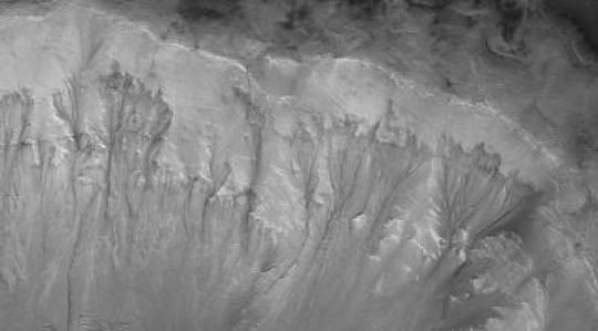 Pemandangan jejak air terlihat di dinding kawah di Mars
