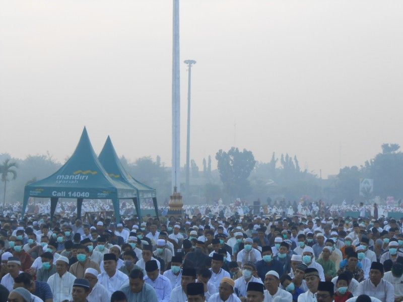 Ribuan umat muslim melaksanakan Sholat Idul Adha di halaman Masjid Raya Annur dengan kondisi kabut asap karhutla yang menyelimuti Kota Pekanbaru, Riau, Minggu (11/8/2019)