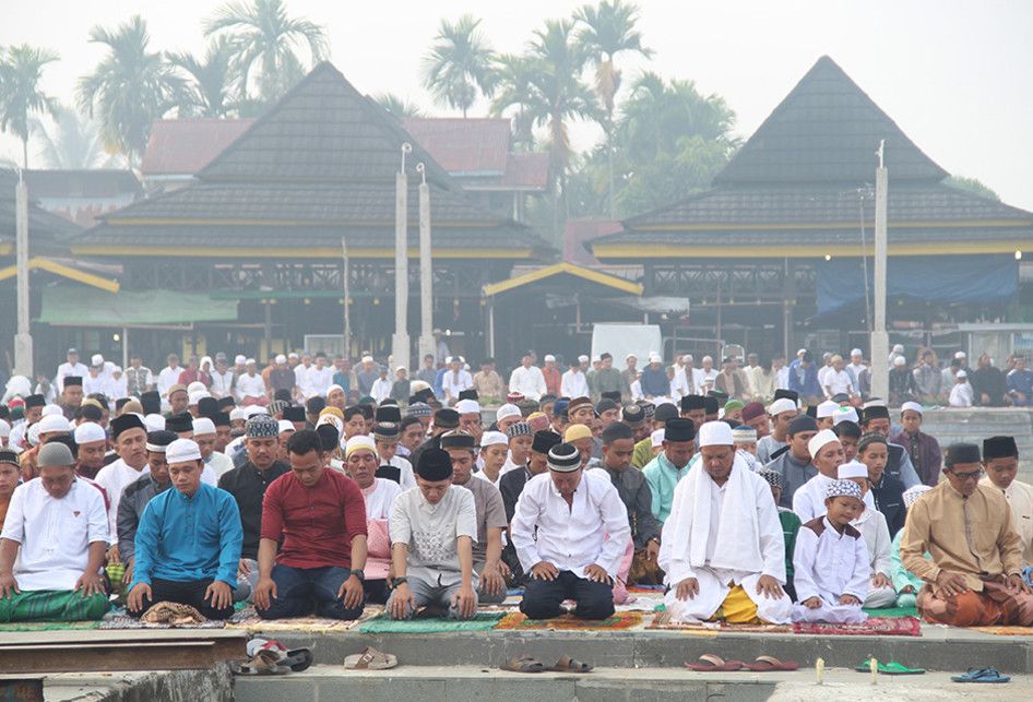 Umat Islam melaksanakan Salat Idul Adha di tepian Sungai Kapuas di Pontianak, Kalimantan Barat, Minggu (11/8/2019). Umat Muslim di Pontianak melaksanakan salat Idul Adha dalam kondisi diselimuti kabut asap pekat yang berasal dari kebakaran hutan dan lahan.