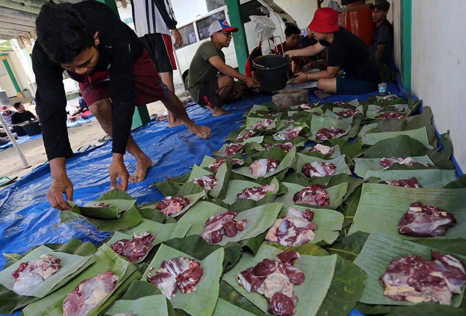 Warga menata daging kurban diatas daun pisang dan daun jati di Blitar, Jawa Timur, Minggu (11/8/2019). Sejumlah warga dan instansi didaerah tersebut memanfaatkan dedaunan dan wadah dari anyaman bambu (besek) untuk membungkus daging kurban yang bertujuan untuk mendukung program pemerintah dalam meminimalisir penggunaan plastik (diet plastik).