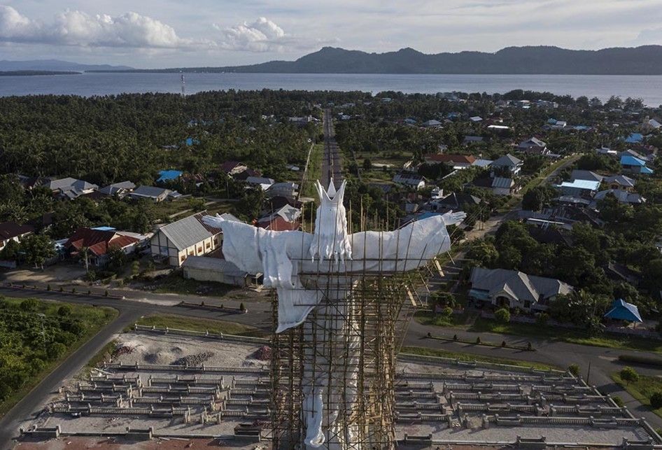 Foto dirilis Senin (12/8/2019), menunjukkan foto aerial Monumen Tuhan Yesus Raja Memberkati dengan latar belakang Kepulauan Talaud di Sulawesi Utara. Meski hadir dengan perjuangan tak mudah, keberadaan BBM Satu Harga di Talaud membawa angin segar untuk perubahan dan menciptakan asa untuk memutar rod