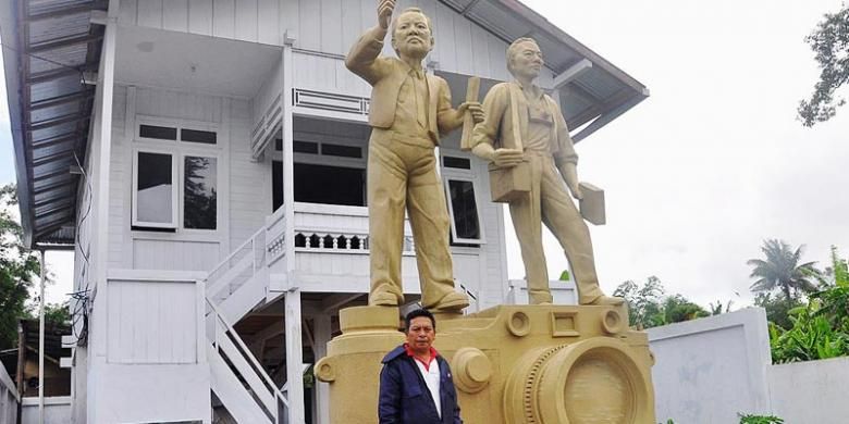 Jolly Rompas, pengelola Tugu Pers Mendur, berdiri di depan patung Mendur bersaudara, putra asli Minahasa.