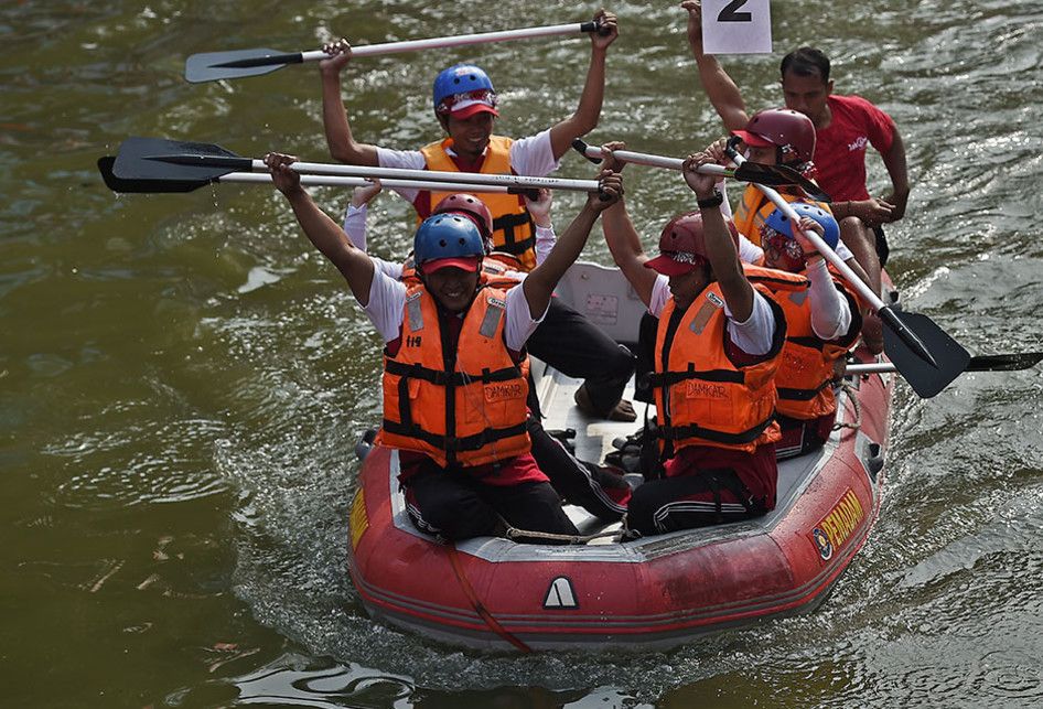 Sejumlah peserta lomba perahu dayung berselebrasi usai mencapai garis finis di Sungai Ciliwung, Pasar Baru, Jakarta Pusat, Jumat (16/8/2019). Pemerintah Kota Administrasi Jakarta Pusat menggelar lomba balap perahu dayung antar instansi untuk memeriahkan HUT Ke-74 Kemerdekaan RI.