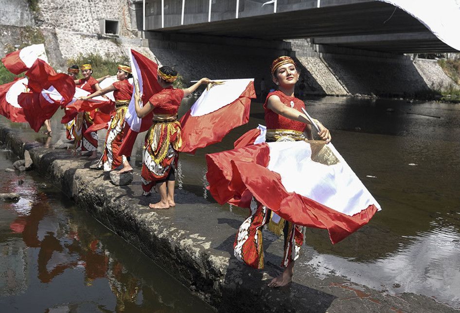 Warga mengibarkan bendera di Sungai Kalianyar, Solo, Jawa Tengah, Sabtu (17/8/2019). Selain untuk merayakan HUT ke-74 Tahun Republik Indonesia, aksi tersebut  digelar sebagai kampanye pelestarian sungai.