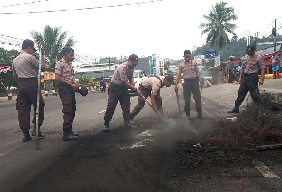 Sejumlah polisi membersihkan sisa kerusuhan di salah satu ruas jalan di Manokwari, Papua Barat, Selasa (20/8/2019). Kondisi Manokwari sudah kondusif dan warga mulai melakukan aktivitas di ruang publik meskipun dalam skala terbatas.