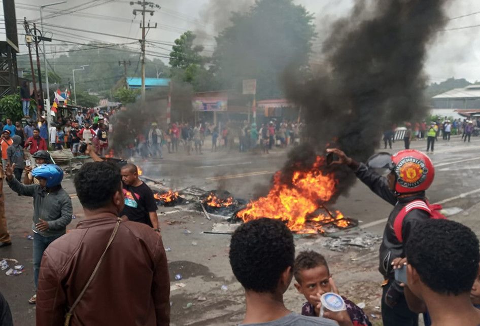 Massa membakar ban saat kerusuhan di pintu masuk Jalan Trikora Wosi Manokwari, Senin (19/8/2019).  Aksi ini merupakan buntut dari kemarahan mereka atas peristiwa yang dialami mahasiswa asal Papua di Surabaya, Malang dan Semarang.