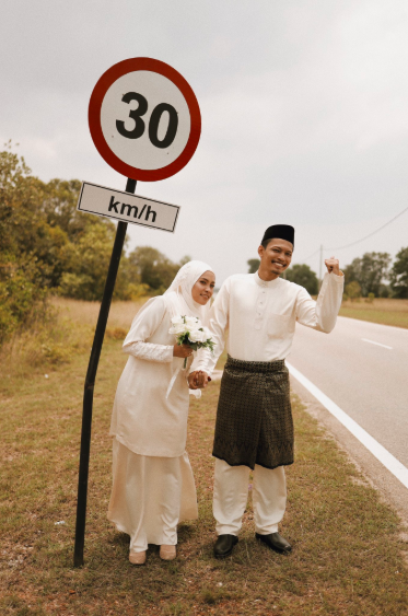 Pasangan ini menggunakan rambu lalu lintas sebagai properti foto pernikahannya
