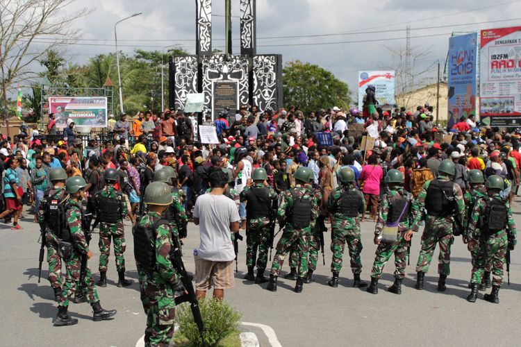 Warga melakukan aksi dengan pengawalan prajurut TNI di Bundaran Timika Indah, Mimika, Papua, Rabu (21/8/2019). Aksi tersebut untuk menyikapi peristiwa yang dialami mahasiswa asal Papua di Surabaya, Malang dan Semarang.