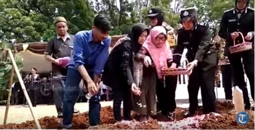 Erik Yudha bersama sang ibu saat menaburkan bunga diatas makam sang ayah Ipda Erwin Yuda Wildani.