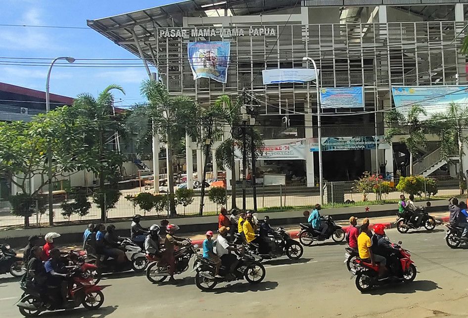 Sejumlah warga mengendarai kendaraan melintasi Pasar Mama Mama Papua seusai aksi unjuk rasa di Jayapura, Papua, Jumat (30/8/2019). Sejumlah bangunan dan kendaraan terbakar saat aksi unjuk rasa yang berakhir rusuh di Jayapura, Kamis kemarin, masih terkait memprotes dugaan tindak rasisme kepada mahasi