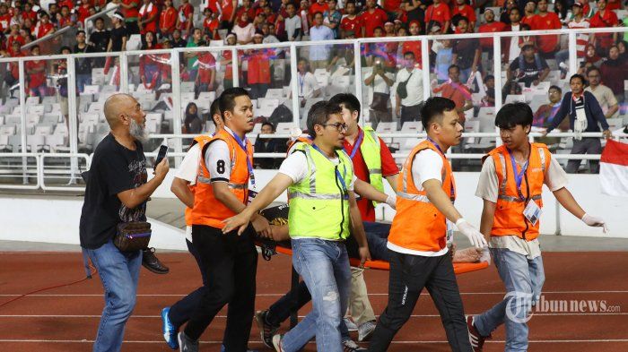 Petugas medis menandu suporter Timnas Malaysia yang mengalami luka saat Timnas Indonesia melawan Timnas Malaysia pada ajang kualifikasi Piala Dunia Qatar 2022 di Stadion Utama Gelora Bung Karno, Jakarta, Kamis (5/9).