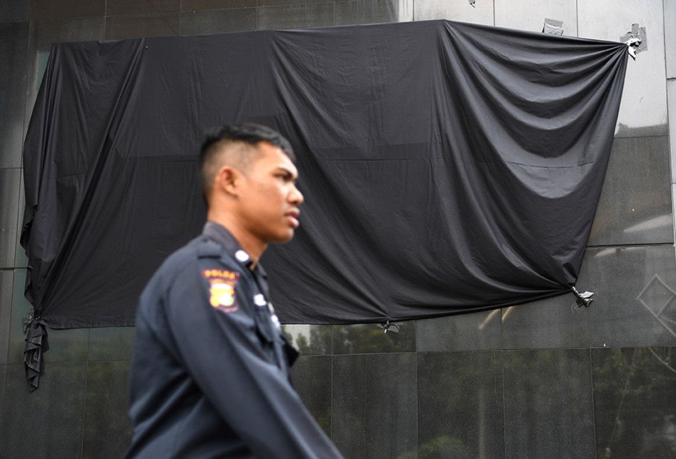 Petugas keamanan melintasi tulisan Komisi Pemberantasan Korupsi (KPK) yang tertutup kain hitam di Gedung Merah Putih KPK, Jakarta, Senin (9/9/2019). Penutupan tulisan KPK dengan kain hitam yang dilakukan sejak Minggu (8/9/2019) itu merupakan bagian dari aksi simbolis jajaran pimpinan hingga pegawai 