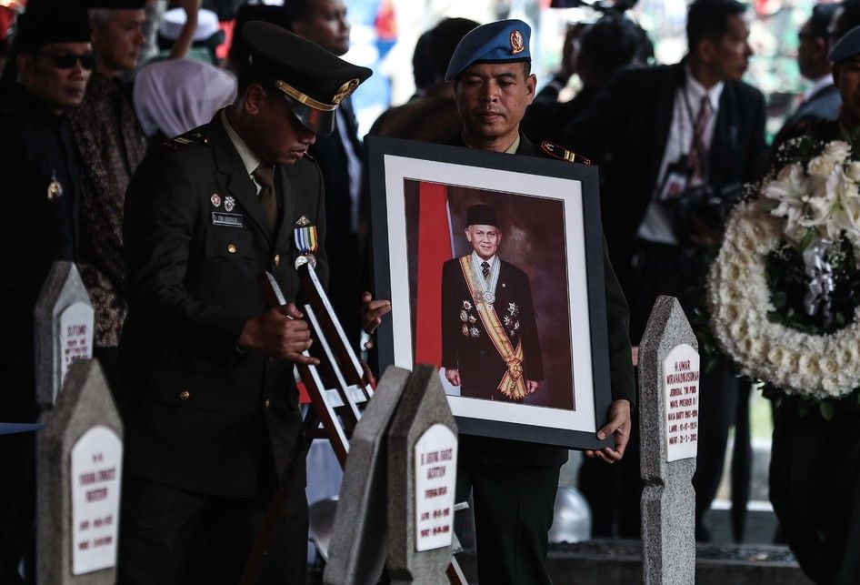 Personel Pasukan Pengamanan Presiden (Paspampres) membawa bingkai foto Presiden ke-3 Republik Indonesia, BJ Habibie menuju liang lahat saat tiba di Taman Makam Pahlawan Nasional Utama Kalibata, Jakarta Selatan, Kamis (12/9/2019). BJ Habibie meninggal dunia pada hari Rabu (11/9/2019) pukul 18.05 WIB 