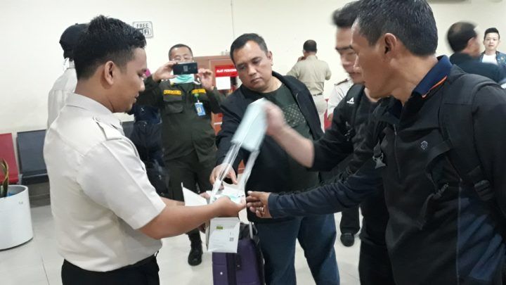 Petugas bandara membagikan masker secara gratis kepada penumpang yang datang di Bandara Sultan Syarif Kasim II, Kota Pekanbaru, Riau, Jumat (13/9/2019).