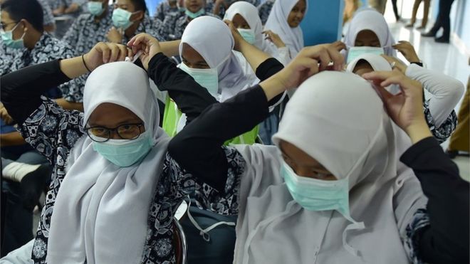 Siswa sekolah menengah di Palembang memasang masker yang dibagikan Dinas Kesehatan Sumsel saat sosialisasi bahaya kabut asap di Palembang, Sumatera Selatan, Kamis (12/9). 
