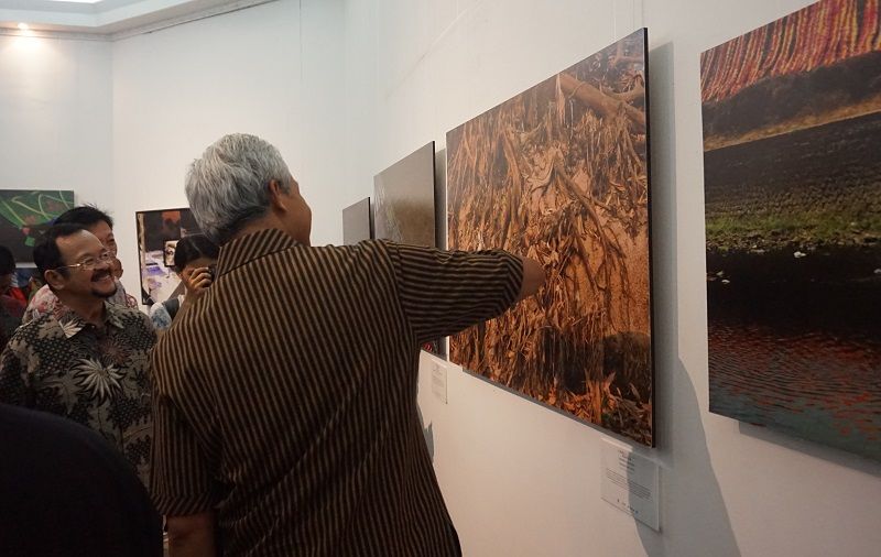 Gubernur Jawa Tengah, Ganjar Pranowo, memberi perhatian pada foto sampah di Bengawan Solo karya Prof Soeprapto Soejono, seusai pembukaan pameran foto 