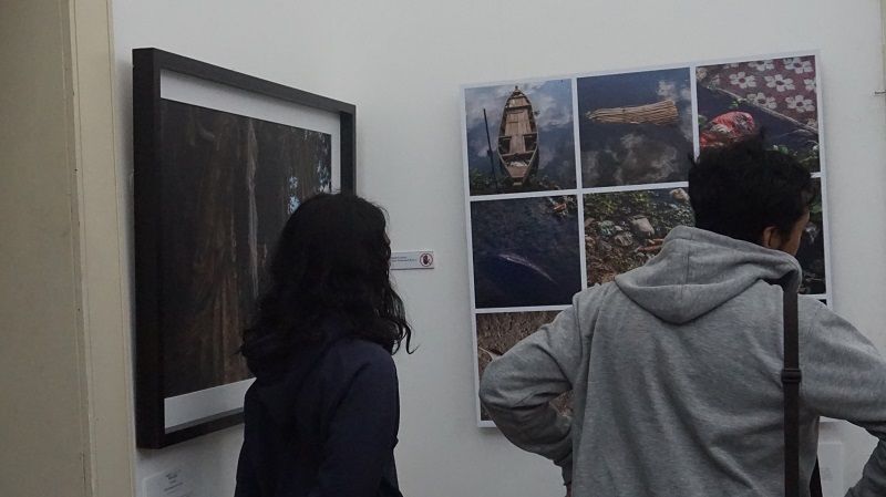 Pengunjung memperhatikan foto karya Dwi Oblo pada pameran foto 