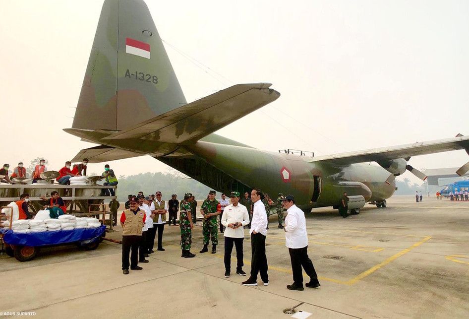 Presiden Jokowi meninjau Pesawat C-130 Hercules milik TNI AU dari Skadron 31 Lanud Halim yang akan dikerahkan untuk mengatasi kebakaran hutan dan lahan di Provinsi Riau, di Lanud Roesmin Nuryadin, Pekanbaru. Pesawat Hercules C-130 Hercules ini sudah dimodifikasi sedemikian rupa sebagai pesawat penci