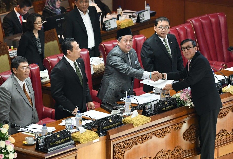 Menkumham Yasonna Laoly (kanan) berjabat tangan dengan Wakil Ketua DPR selaku pimpinan sidang Fahri Hamzah (ketiga kanan), disaksikan Ketua DPR Bambang Soesatyo (kedua kiri) dan Wakil Ketua DPR Fadli Zon (kedua kanan), dan Utut Adianto (kiri) usai menyampaikan pandangan akhir pemerintah terhadap rev