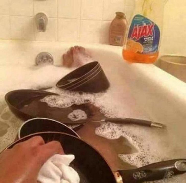 Orang ini mandi sambil mencuci peralatan masaknya.