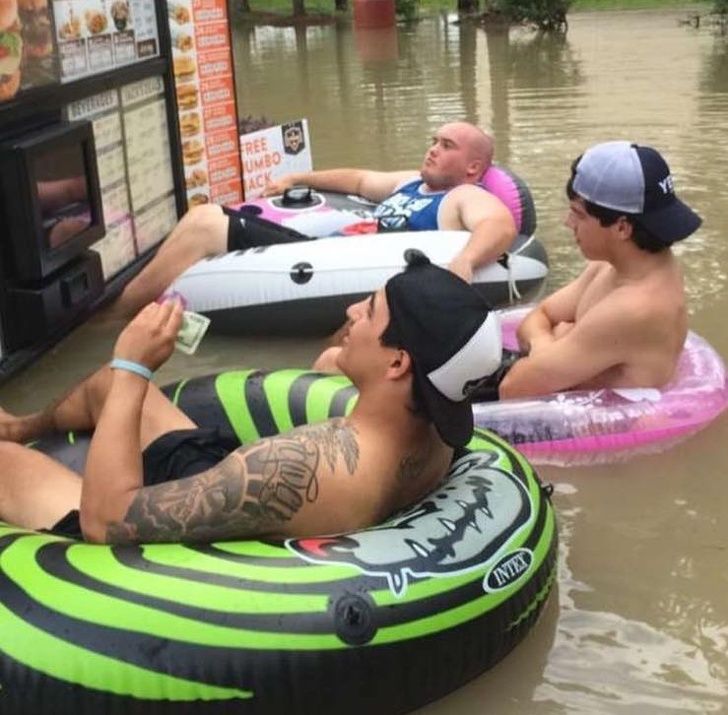 Para pria ini menggunakan penampung sebagai kendaraannya, kala ingin memesan makanan saat kota mereka sedang dilanda banjir.