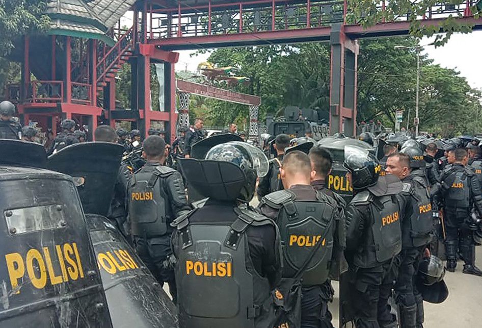 Sejumlah personel polisi berjaga di sebuah universitas di Jayapura, Papua, menyusul kerusuhan yang terjadi, Senin (23/9/2019) siang. Gubernur Papua Lukas Enembe menyebut terdapat korban jiwa dan luka-luka dari kerusuhan yang masih ditelusuri penyebabnya tersebut.