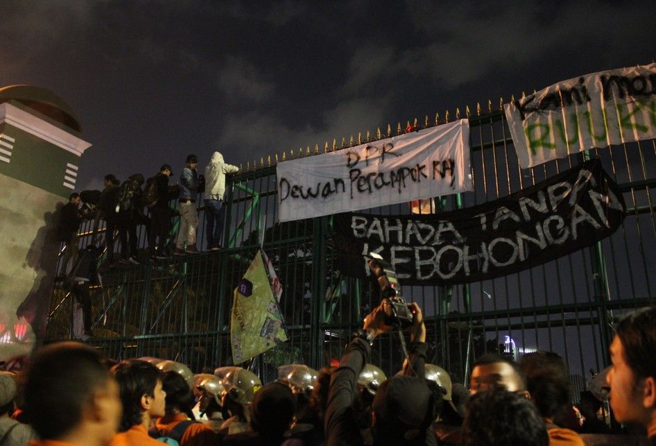 Mahasiswa menaiki pagar Gedung DPR/MPR pada aksi penolakan RKUHP , Jalan Gatot Subroto, Senayan, Jakarta Pusat, Senin (23/9/2019).