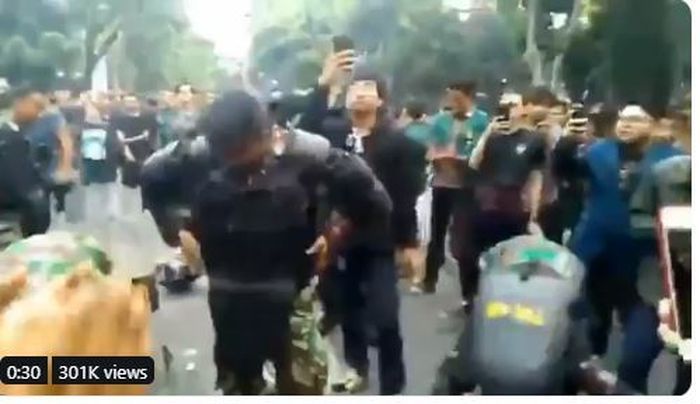 Anggota TNI AL terlihat sedang melepas rompi anti peluru demi dekati mahasiswa