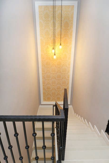 Menambah wallpaper di salah satu bidang dinding menjadi cara mempercantik area bordes. Warna kuning yang senada dengan lampu menambah kehangatan di tangga tersebut.