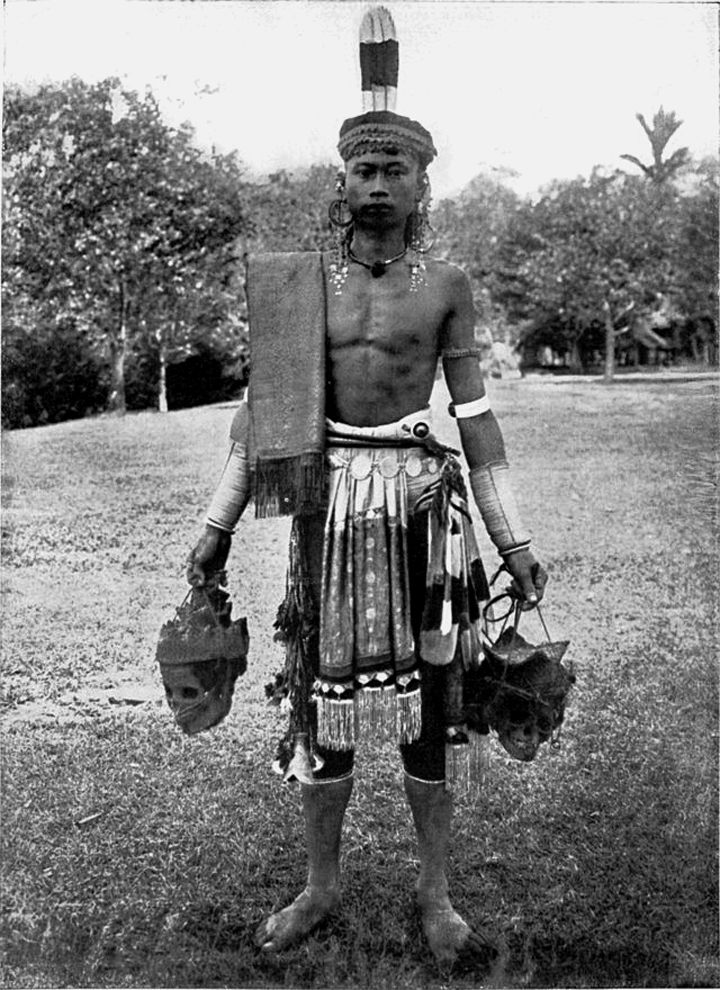 Seorang Dayak pemburu kepala di Borneo sekitar 1900-1912. Setiap satu atau dua tahun sekali the Dayak Iban menyelenggarakan adat Gawai Autu untuk menghormati arwah leluhur yang dipercaya berada disekeliling kepala yang tergantung di rumah mereka. Dalam upacara adat itu mereka berharap mendapatkan berkah dan keberuntungan. 