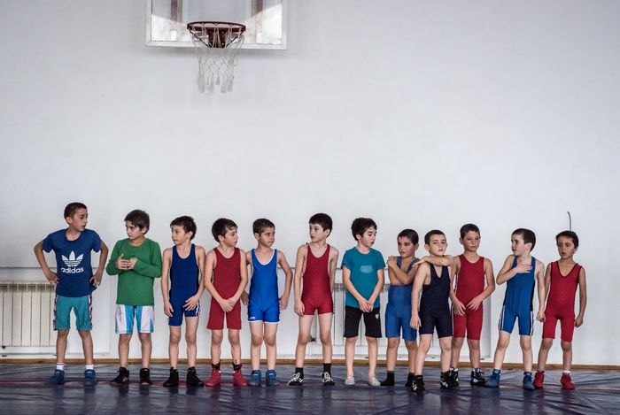 Anak-anak berbaris sebelum sesi pelatihan di sekolah gulat bernama saudara Saitiyev.
