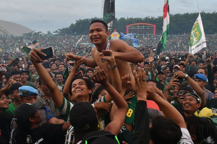Pemain Persebaya Surabaya, Oktafianus Fernando, saat merayakan gelar juara Piala Gubernur Jatim 2020 di tengah kerumunan suporter Persebaya, Bonek, di Stadion Gelora Delta Sidoarjo, Kamis (20/2/2020).