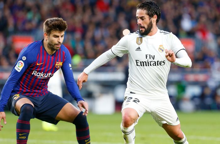 Pemain Real Madrid, Isco, berusaha melewati bek Barcelona, Gerard Pique, pada laga El Clasico, Oktober 2018.