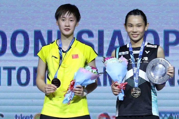 Pebulu tangkis tunggal putri China, Chen Yufei (kiri), dan Tai Tzu Ying (Taiwan) berpose di podium Indonesia Open 2018, di Istora Senayan Jakarta, Minggu (8/7/18).