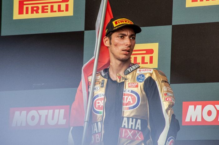 Pembalap Pata Yamaha asal Turki, Toprak Razgatlioglu berdiri di podium usai meraih gelar juara dunia WSBK 2021 di Sirkuit Mandalika, Lombok, Indonesia, Minggu (21/11/2021)