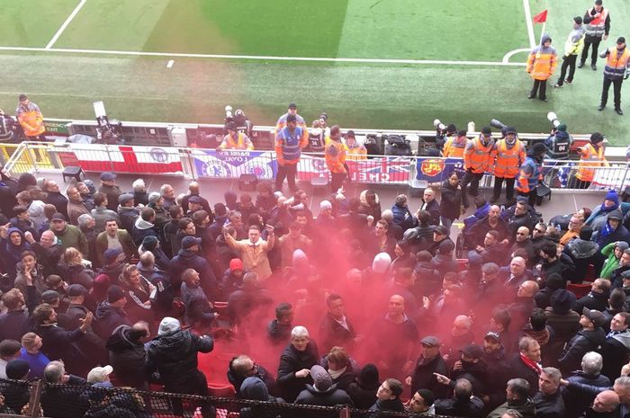 Fan Liverpool melemparkan bom asap ke arah tribune suporter Chelsea.