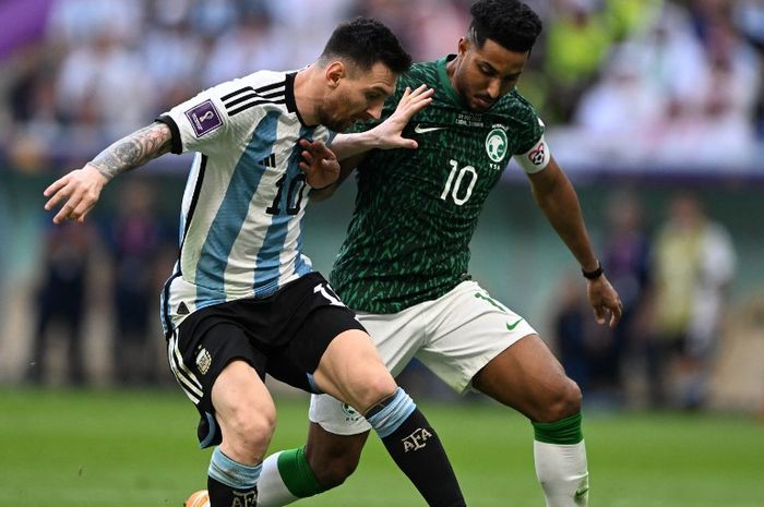 Lionel Messi (kiri) berduel dengan Salem Al-Dawsari dalam partai Piala Dunia 2022 antara timnas Argentina vs timnas Arab Saudi di Stadion Lusail, Qatar (22/11/2022).